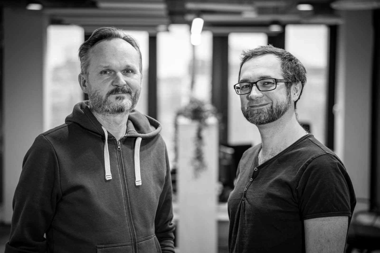 Grzegorz Miechowski i Przemysław Marszał, współzałożyciele 11 bit studios, na czarno białym zdjęciu w biurze